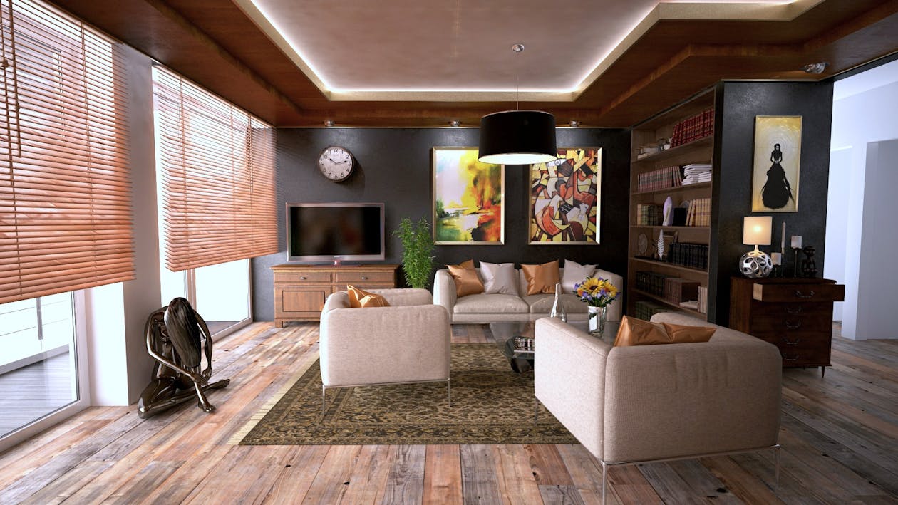 A professional real estate agent shakes hands with a happy couple inside a bright, modern home, representing the trust and value of expert guidance in securing a property.