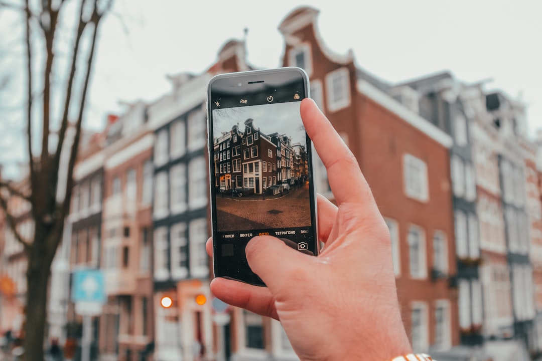 Close-up of a hand holding a smartphone displaying a modern real estate app, symbolizing how AI personalizes the property search.