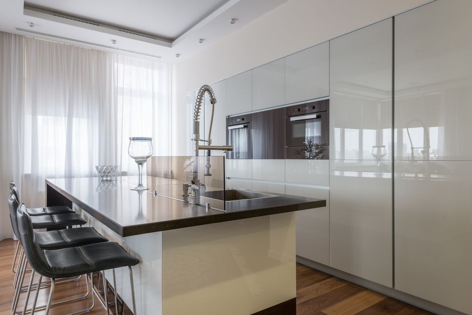 A set of new house keys rests on a bright, modern kitchen island, representing the successful outcome of a well-negotiated home purchase.